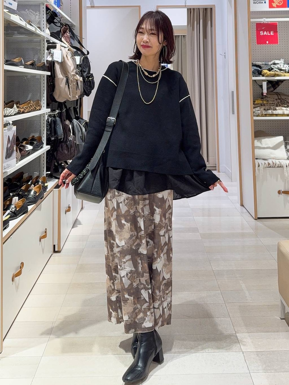 ブラック系のTシャツ/カットソー、ブラック系のワンピース、ブラック系のブーツを着用したレディースの冬コーディネートの4枚目の写真