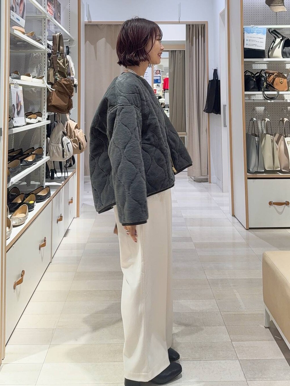 グレー系のブルゾン、グレー系のその他パンツ、ブラック系のボストンバッグを着用したレディースの秋コーディネートの6枚目の写真