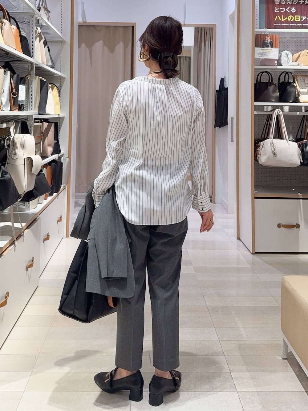 ブラック系のローファー、グレー系のスラックス、ブラック系のトートバッグを着用したレディースの冬コーディネートの9枚目の写真