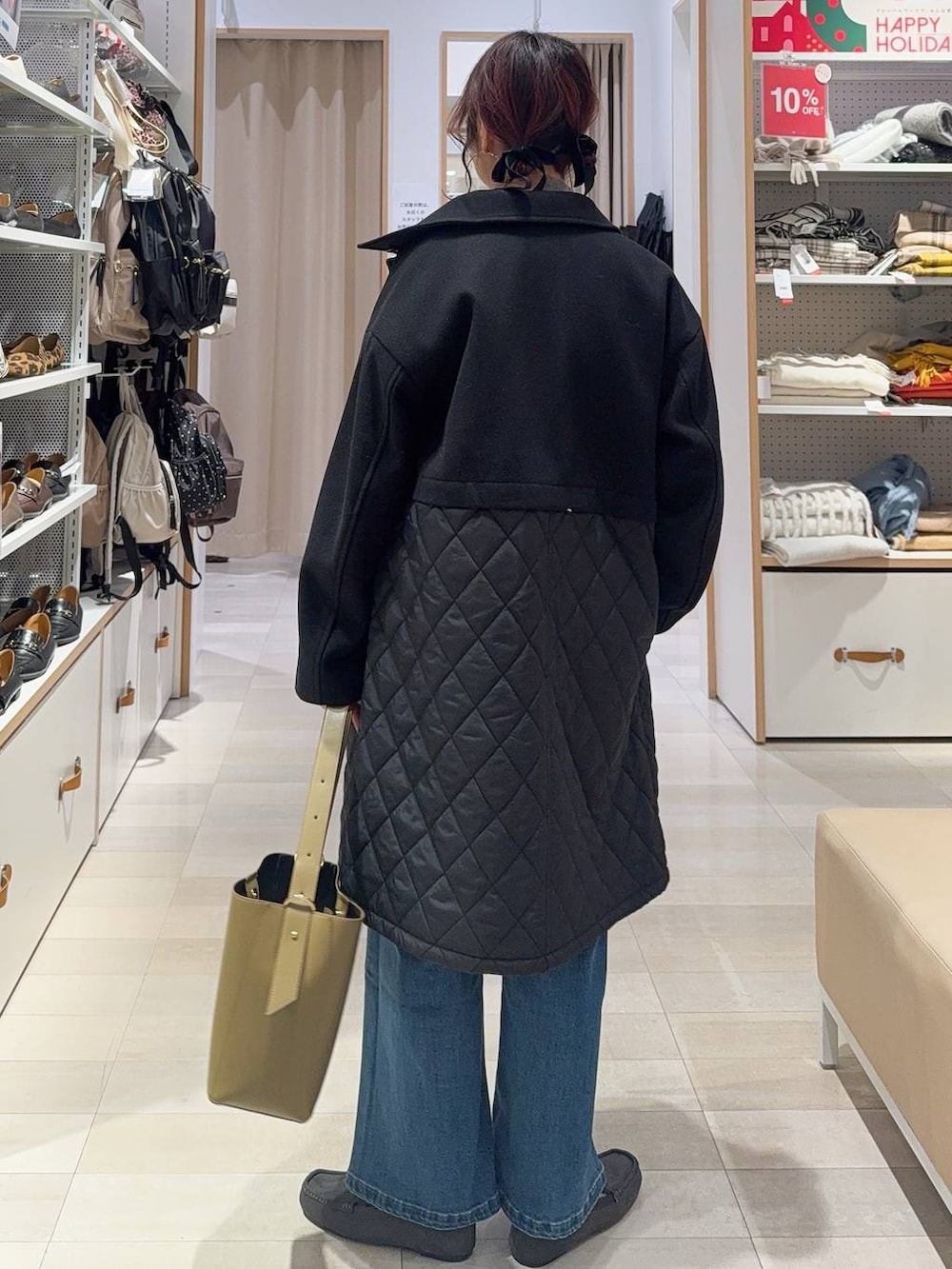 グリーン系のショルダーバッグ、ブラック系のステンカラーコート、ホワイト系のTシャツ/カットソーを着用したレディースの冬コーディネートの5枚目の写真