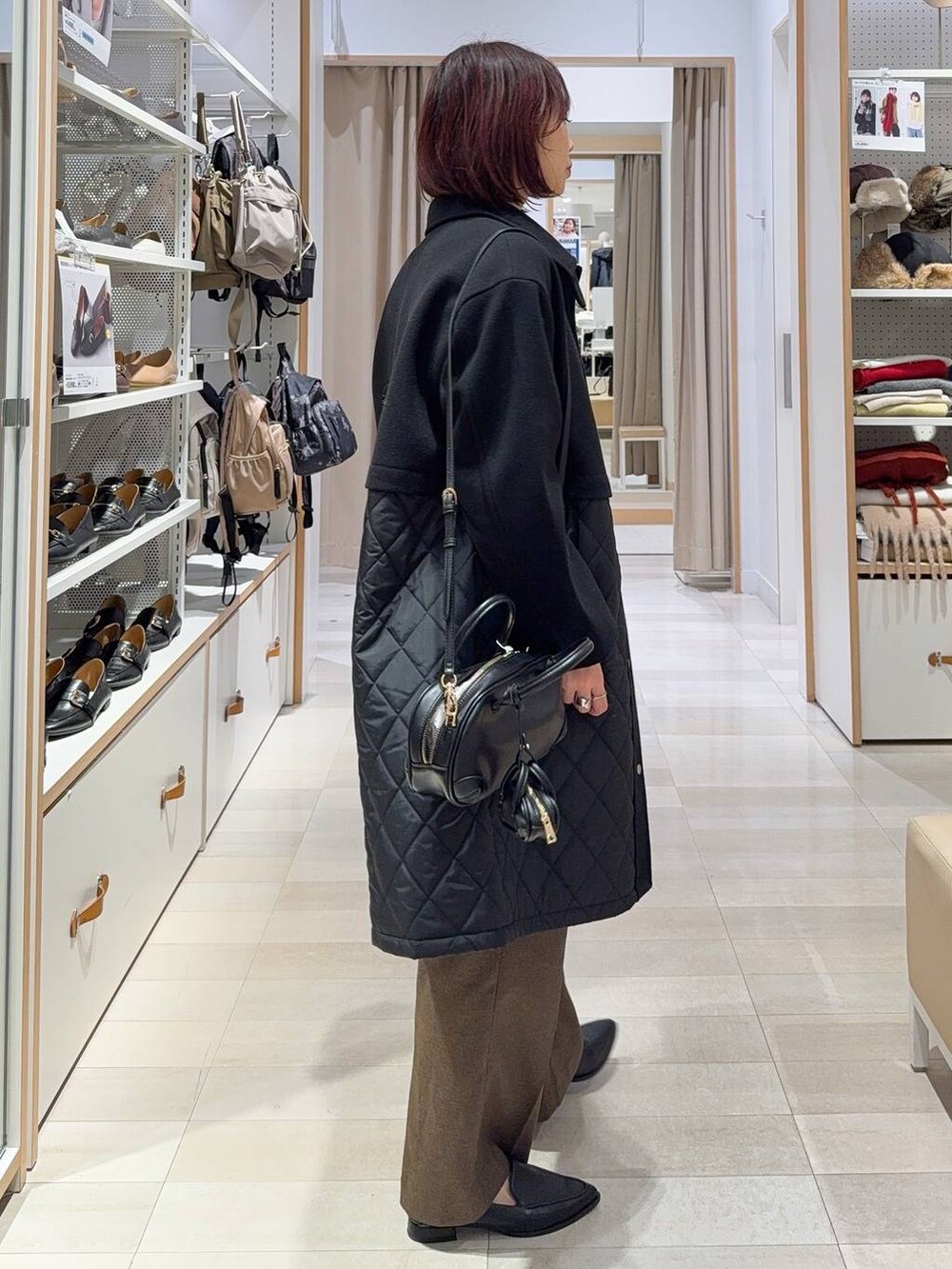 ブラック系のステンカラーコート、ブラウン系のその他パンツ、ブラック系のパンプスを着用したレディースの秋コーディネートの3枚目の写真