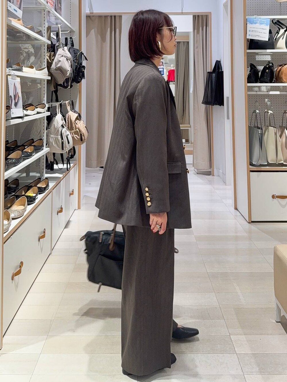 ブラック系のトートバッグ、ブラック系のシャツ/ブラウス、ブラック系のその他シューズを着用したレディースの秋コーディネートの3枚目の写真