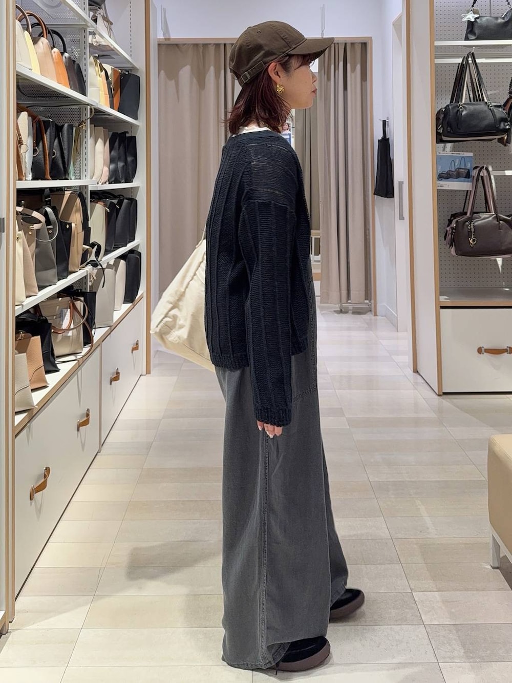 ブラック系のスニーカー、ベージュ系のショルダーバッグ、ホワイト系のTシャツ/カットソーを着用したレディースの春コーディネートの3枚目の写真