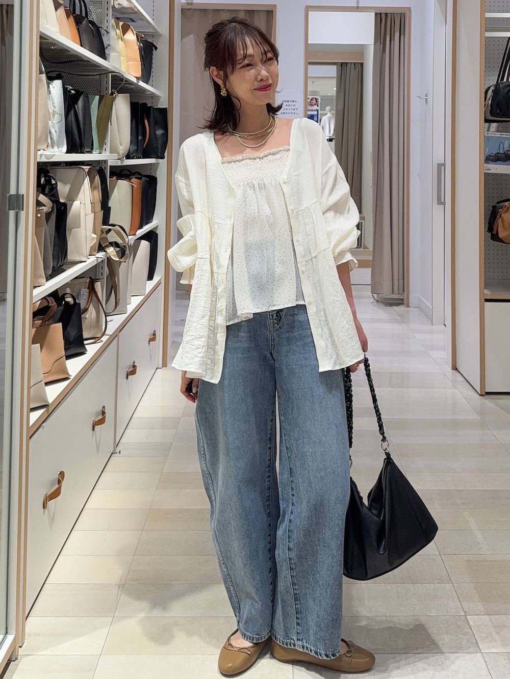 ブラック系のTシャツ/カットソー、ブラック系のスラックス、ブルー系のデニムパンツを着用したレディースの春コーディネートの2枚目の写真