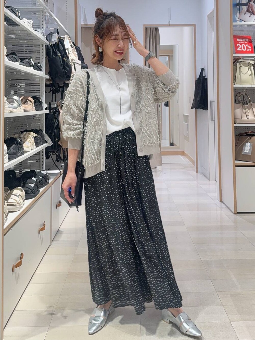 ブルー系のデニムパンツ、ブラック系のショルダーバッグ、ブラック系のタンクトップを着用したレディースの春コーディネートの2枚目の写真