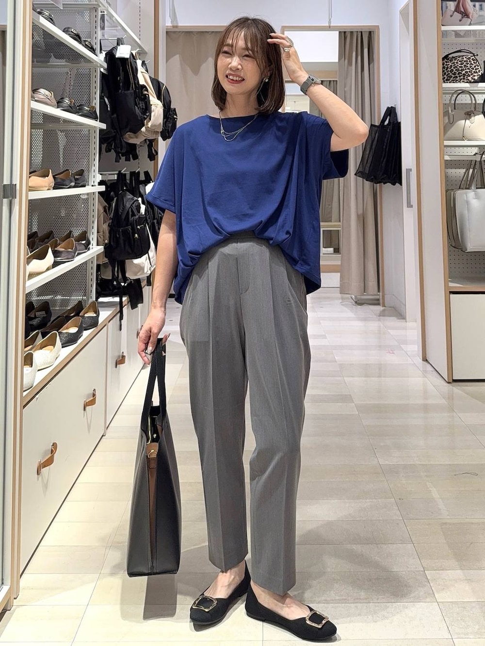 ホワイト系のショルダーバッグ、ブラック系のパンプス、グレー系のスカートを着用したレディースの夏コーディネートの3枚目の写真