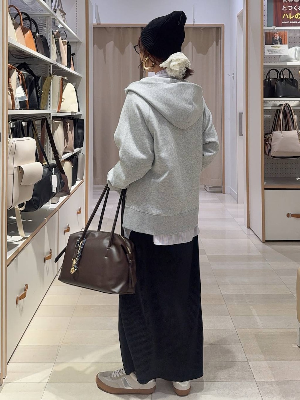 ホワイト系のスニーカー、ブラウン系のボストンバッグ、グレー系のパーカーを着用したレディースの春コーディネートの9枚目の写真