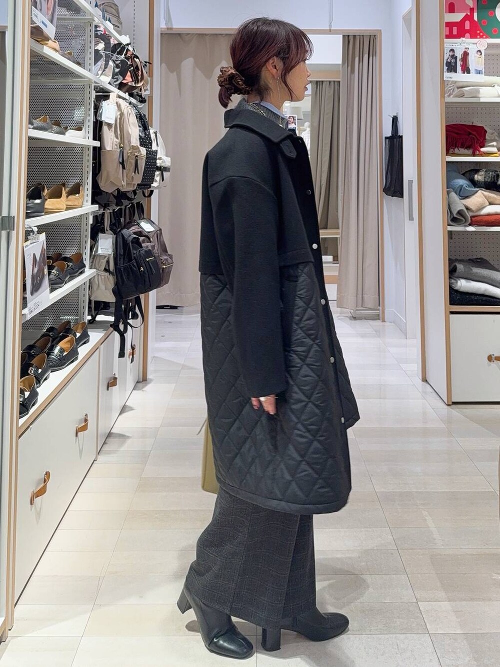 グリーン系のショルダーバッグ、ブラック系のステンカラーコート、ブルー系のシャツ/ブラウスを着用したレディースの冬コーディネートの3枚目の写真