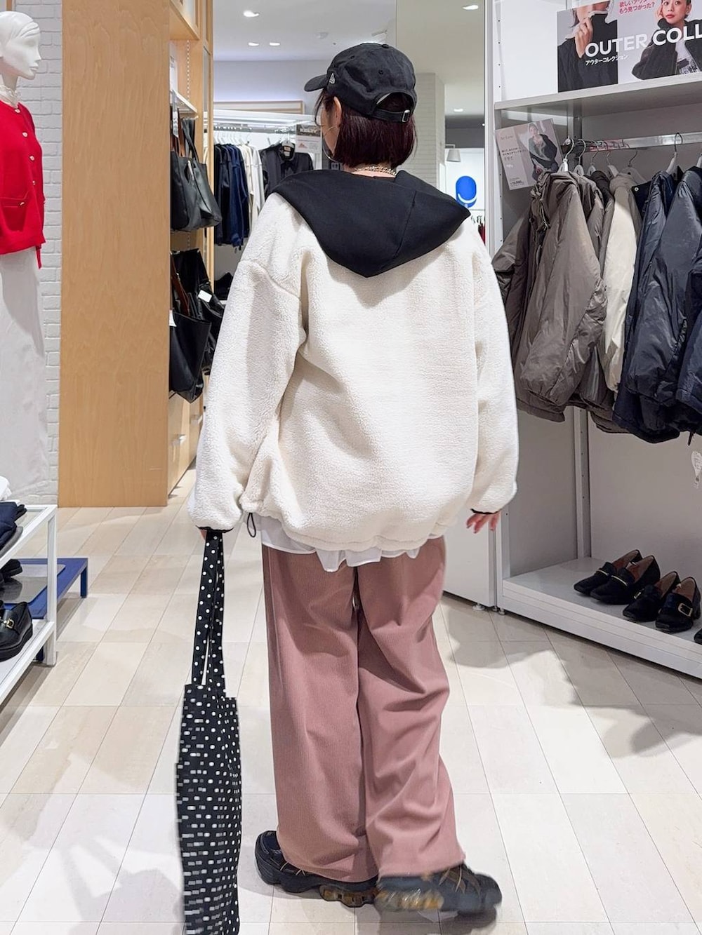 ブラック系のトートバッグ、ホワイト系のブルゾン、ピンク系のその他パンツを着用したレディースの冬コーディネートの4枚目の写真