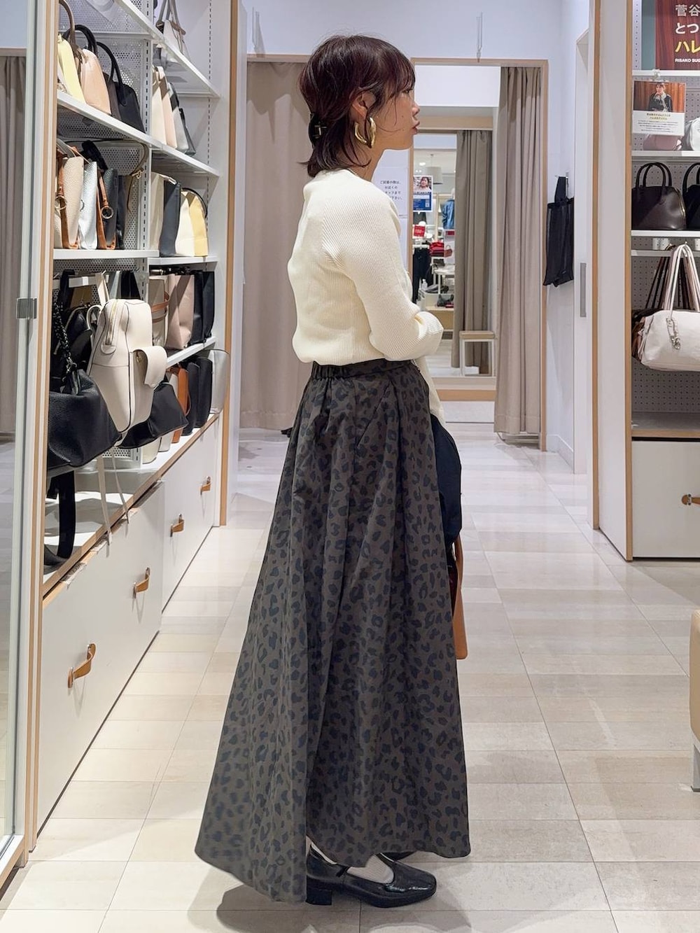 ブラウン系のショルダーバッグ、ブルー系のテーラードジャケット、その他のスカートを着用したレディースの冬コーディネートの7枚目の写真