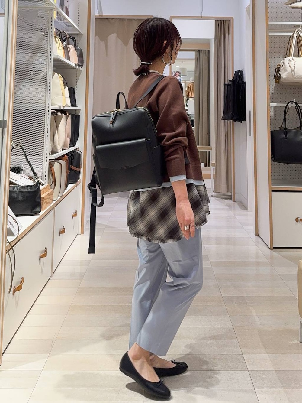 ブラック系のバレエシューズ、ブルー系のスラックス、ブラック系のバックパック/リュックを着用したレディースの冬コーディネートの6枚目の写真