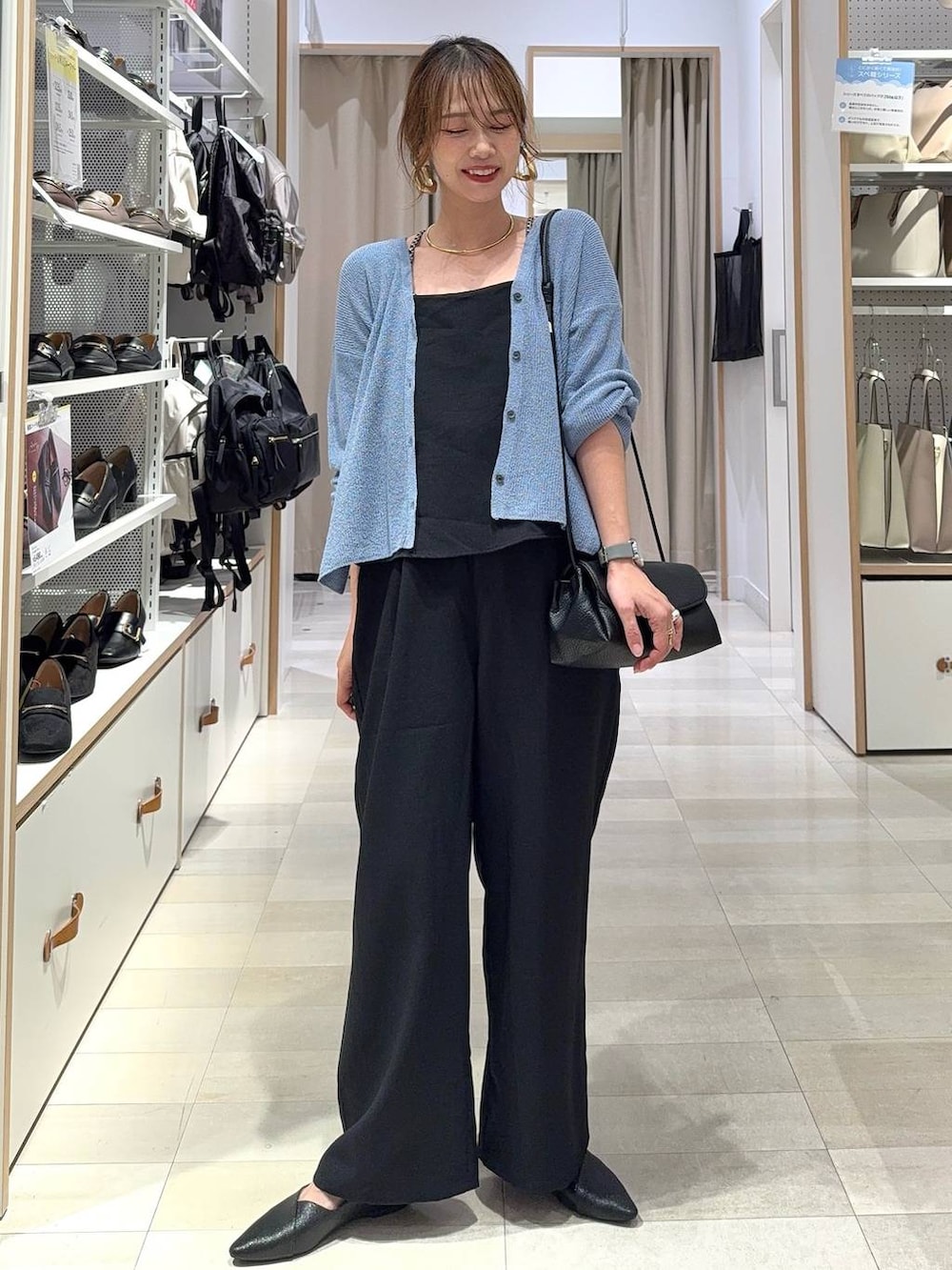 ベージュ系のパンプス、ブルー系のスラックス、ピンク系のカーディガン/ボレロを着用したレディースの秋コーディネートの2枚目の写真