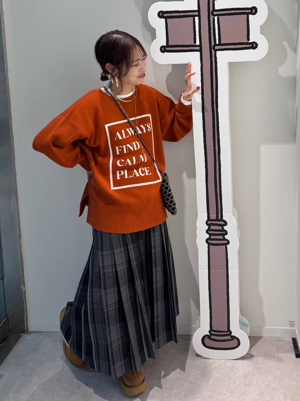 ブラック系のショルダーバッグ、ブルー系のチェスターコート、イエロー系のブーツを着用したレディースの冬コーディネートの4枚目の写真