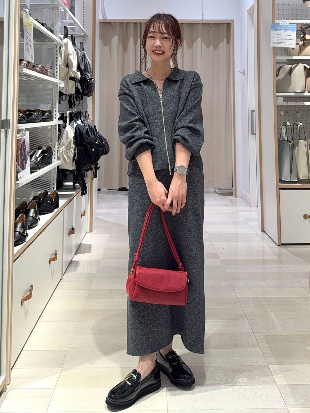 ブラック系のスニーカー、ブルー系のデニムジャケット、シルバー系のハンドバッグを着用したレディースの秋コーディネートの2枚目の写真