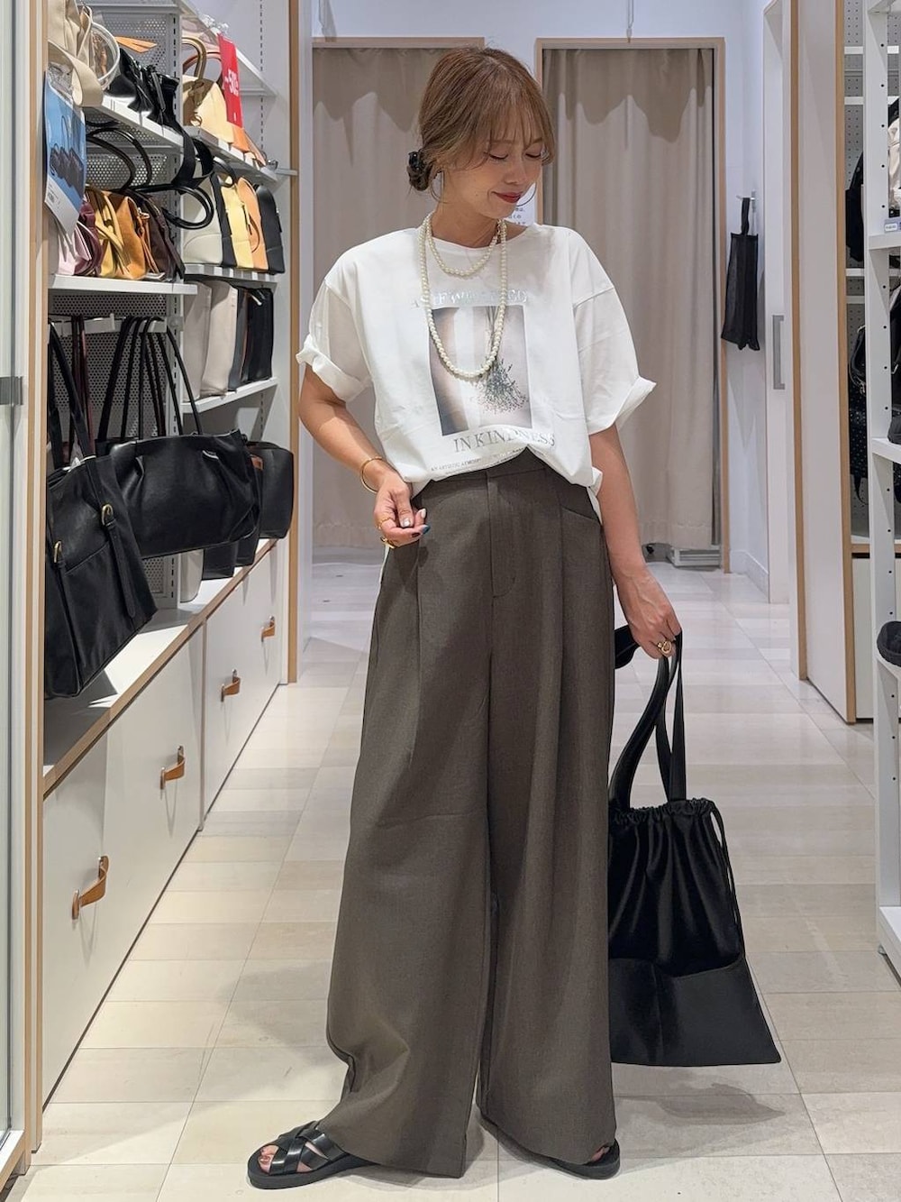 ホワイト系のTシャツ/カットソー、ブラウン系のボディバッグ/ウエストポーチ、ブラウン系のサンダルを着用したレディースの夏コーディネートの2枚目の写真