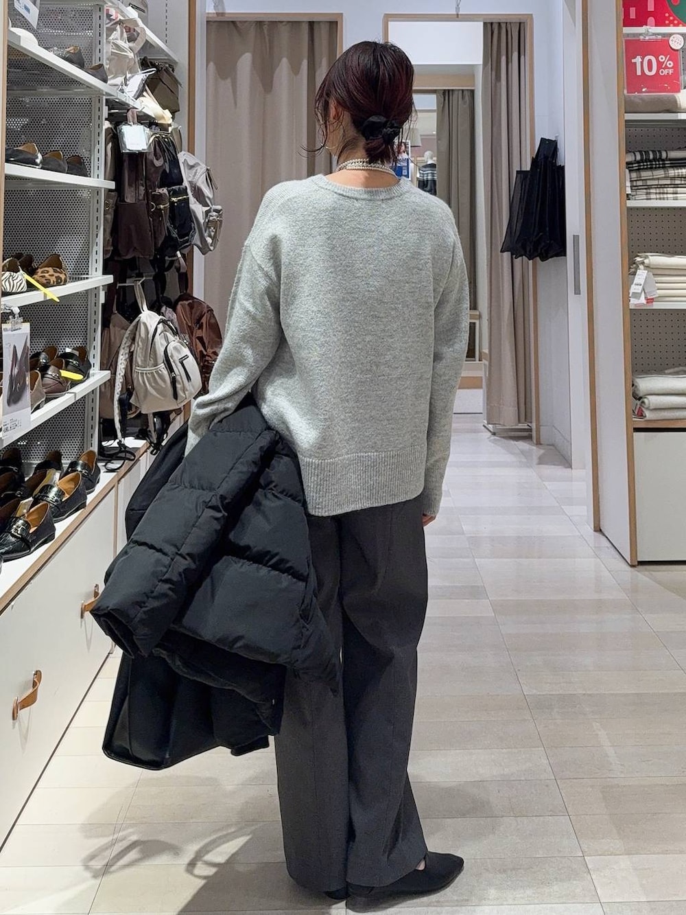 ブラック系のパンプス、ブラック系のダウンジャケット/コート、シルバー系のニット/セーターを着用したレディースの冬コーディネートの6枚目の写真