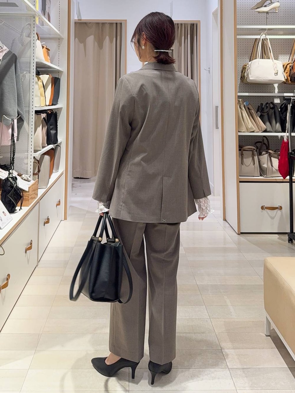 ホワイト系のキャミソール、ホワイト系のTシャツ/カットソー、ブラウン系のスラックスを着用したレディースの冬コーディネートの6枚目の写真