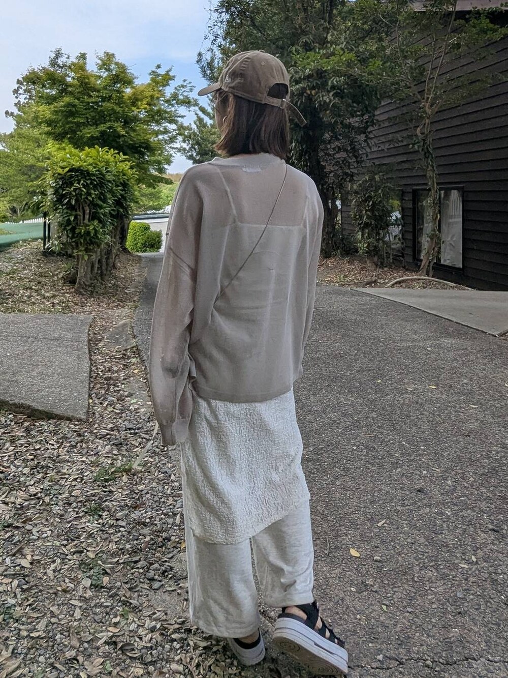 イエロー系のショルダーバッグ、ホワイト系のキャミソール、ベージュ系のニット/セーターを着用したレディースの春コーディネートの4枚目の写真