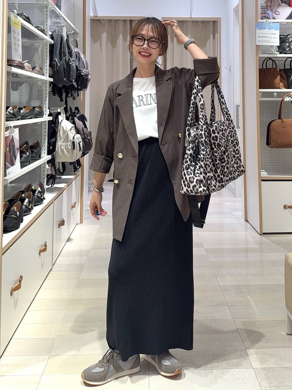 ブラック系のキャミソール、ブラウン系のテーラードジャケット、ブラウン系のスラックスを着用したレディースの秋コーディネートの8枚目の写真