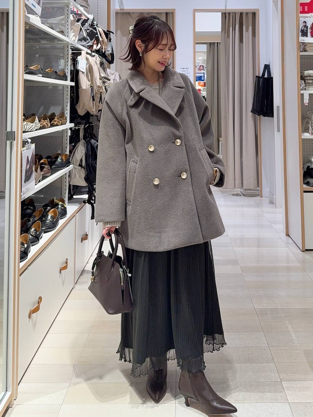 ブラウン系のチェスターコート、ブラック系のその他パンツ、ホワイト系のTシャツ/カットソーを着用したレディースの冬コーディネートの4枚目の写真