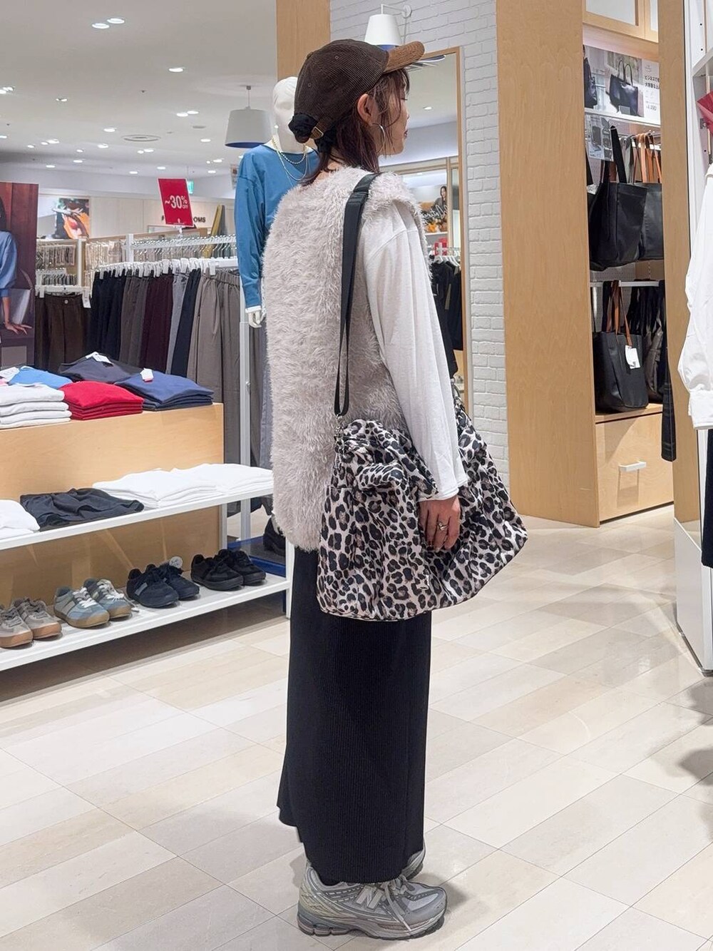 その他のトートバッグ、ブラック系のスカート、ベージュ系のベストを着用したレディースの秋コーディネートの4枚目の写真