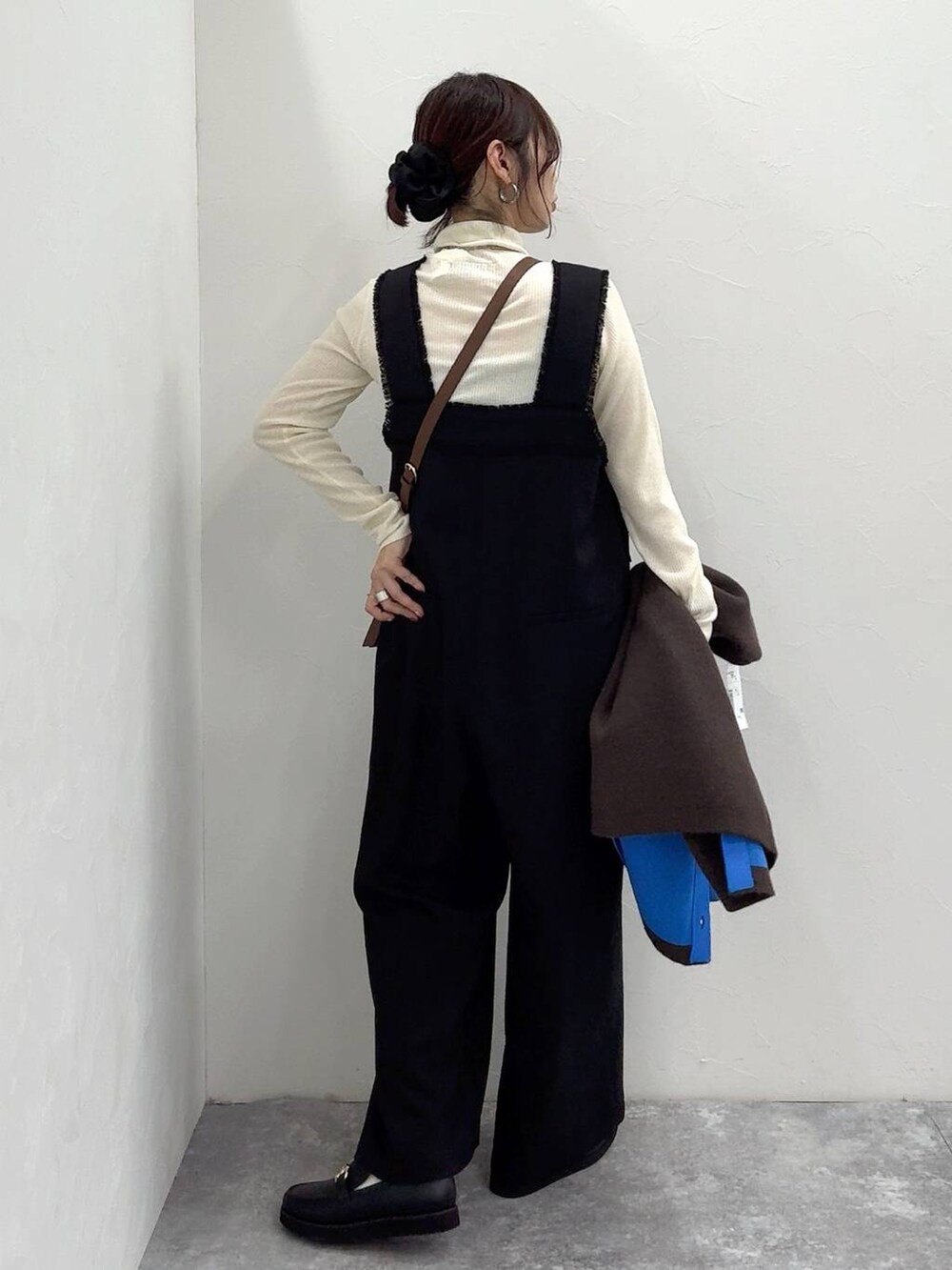 ブラック系のローファー、ブラック系のサロペット/オーバーオール、ホワイト系のニット/セーターを着用したレディースの冬コーディネートの6枚目の写真