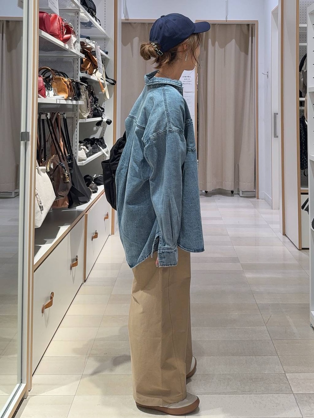 ホワイト系のスニーカー、ブラック系のショルダーバッグ、ホワイト系のTシャツ/カットソーを着用したレディースの秋コーディネートの5枚目の写真