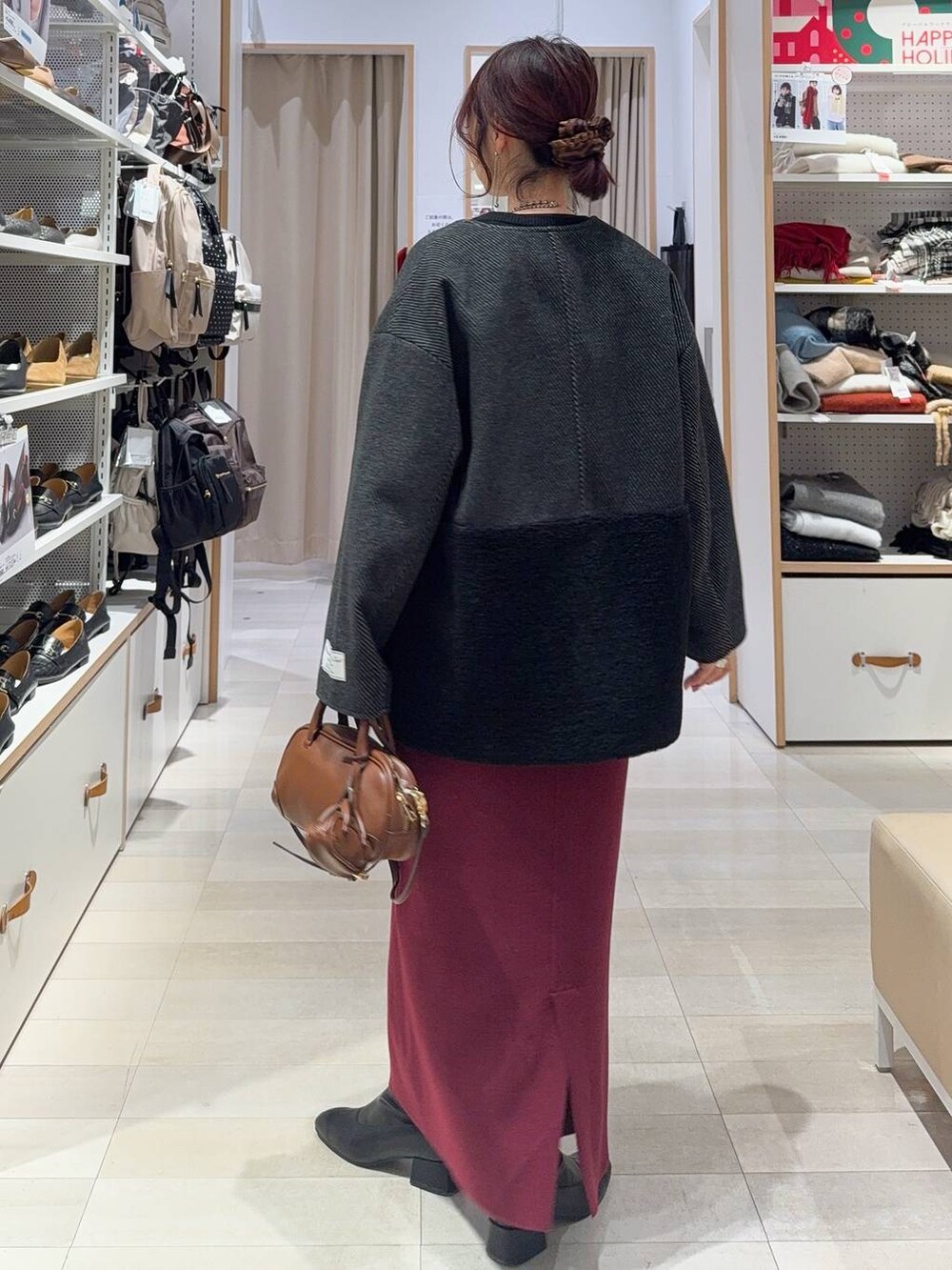 ブラック系のニット/セーター、レッド系のスカート、ブラック系のTシャツ/カットソーを着用したレディースの冬コーディネートの4枚目の写真