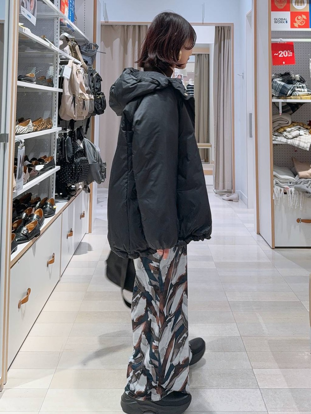 ブラック系のショルダーバッグ、ブラック系のダウンジャケット/コート、ブラック系のブーツを着用したレディースの冬コーディネートの5枚目の写真