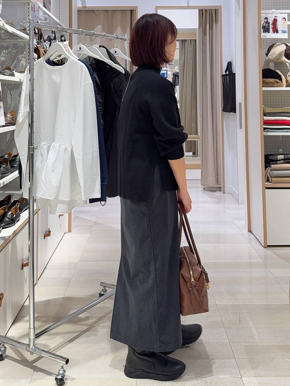 ブラウン系のボストンバッグ、ホワイト系のカーディガン/ボレロ、グレー系のスカートを着用したレディースの秋コーディネートの7枚目の写真