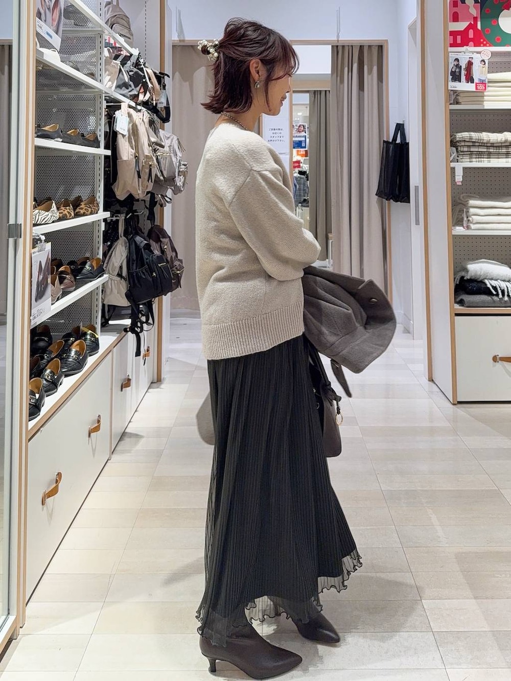 ブラウン系のショルダーバッグ、ブラウン系のチェスターコート、グレー系のワンピースを着用したレディースの冬コーディネートの7枚目の写真