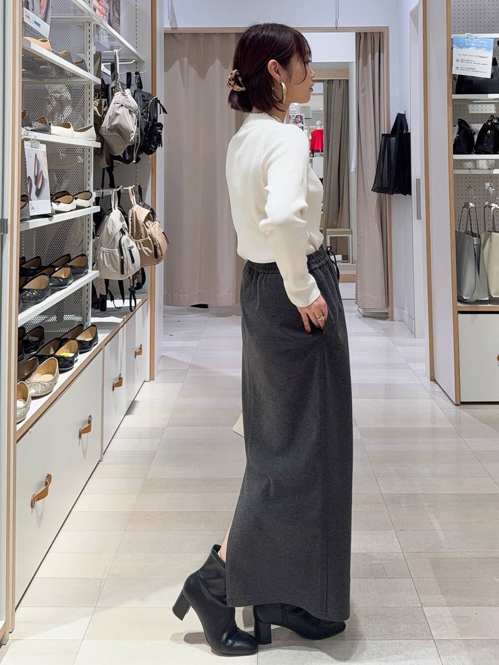 ホワイト系のショルダーバッグ、ブラック系のブーツ、ブラウン系のバレッタ/ヘアクリップを着用したレディースの秋コーディネートの6枚目の写真