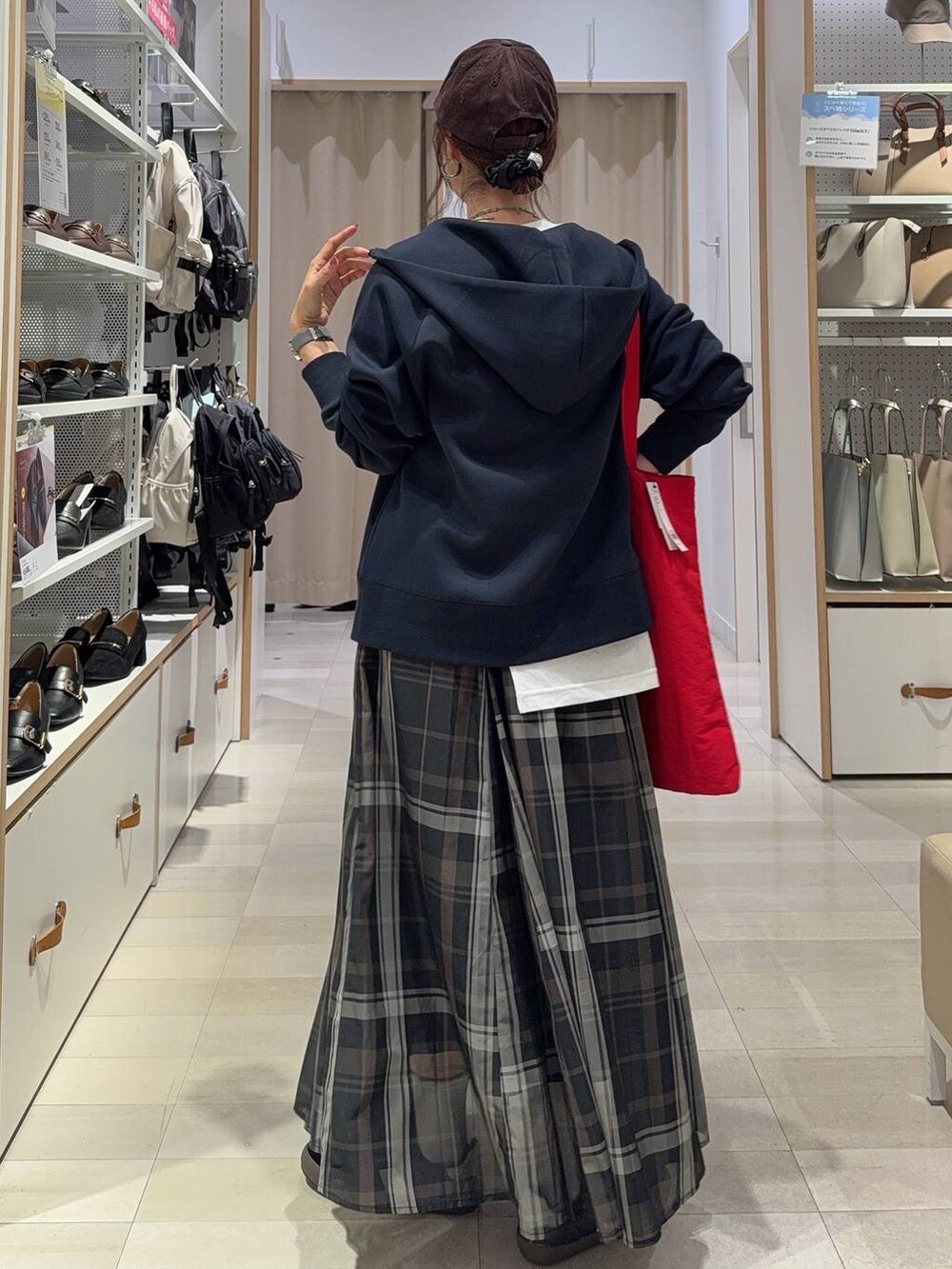 ブラック系のスニーカー、ブラック系のスカート、ホワイト系のTシャツ/カットソーを着用したレディースの秋コーディネートの4枚目の写真