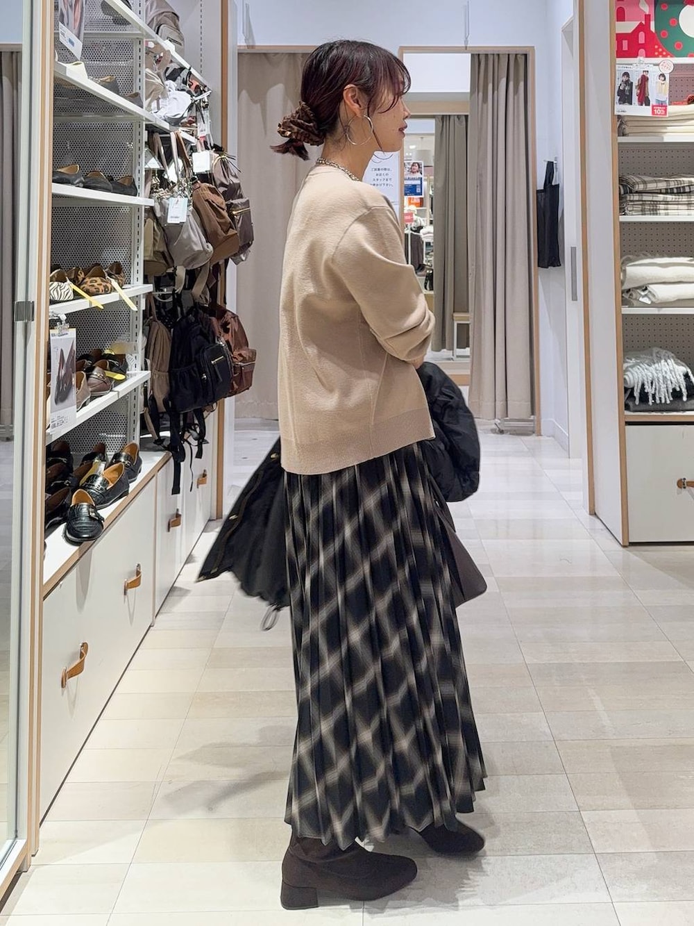 ブラウン系のショルダーバッグ、ブラック系のダウンジャケット/コート、ベージュ系のカーディガン/ボレロを着用したレディースの冬コーディネートの8枚目の写真