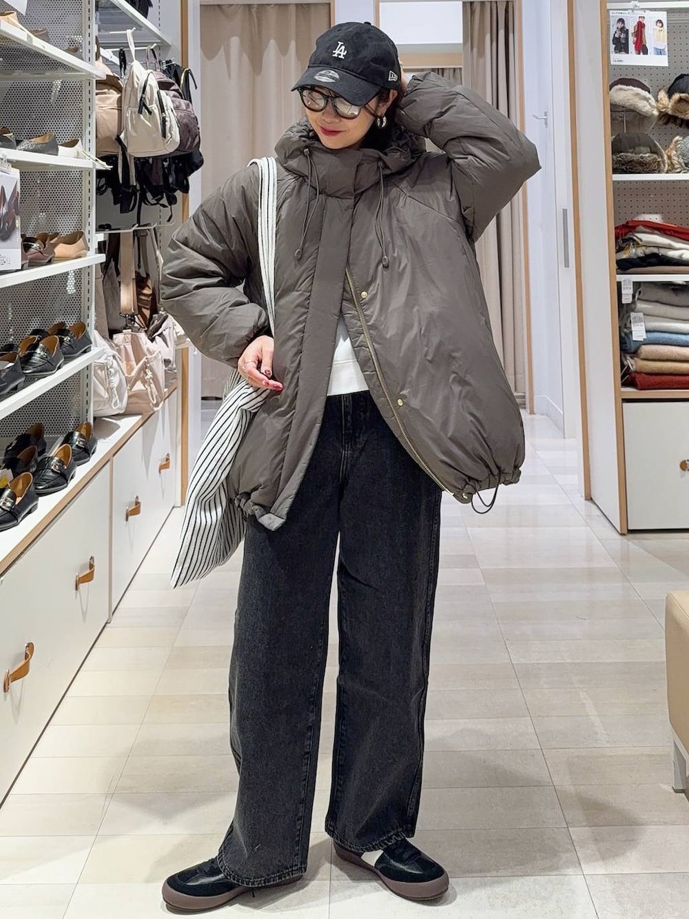 ブラウン系のダウンジャケット/コート、グレー系のスカート、ブラック系のハンドバッグを着用したレディースの冬コーディネートの4枚目の写真