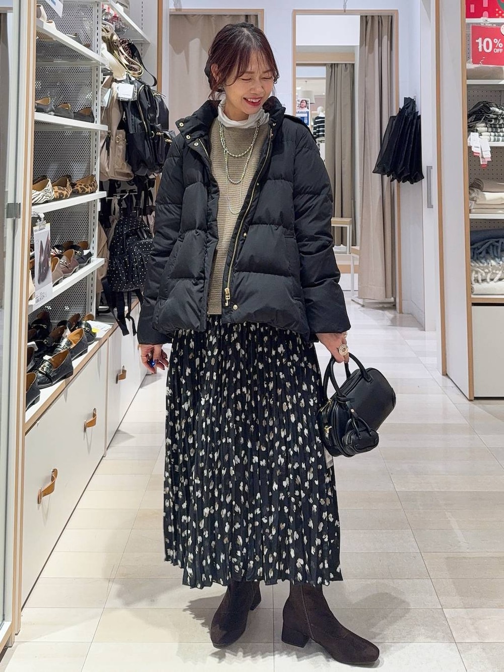 ブラック系のダウンジャケット/コート、ホワイト系のTシャツ/カットソー、ブラウン系のニット/セーターを着用したレディースの冬コーディネートの2枚目の写真