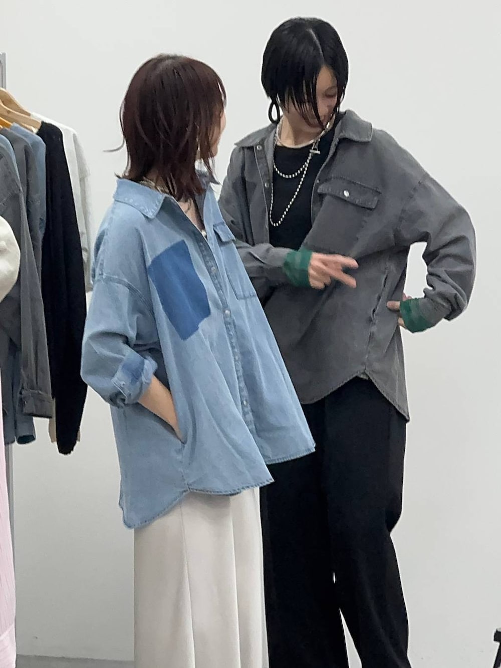 ブラック系のスニーカー、ホワイト系のベスト、シルバー系のネックレスを着用したレディースの春コーディネートの3枚目の写真