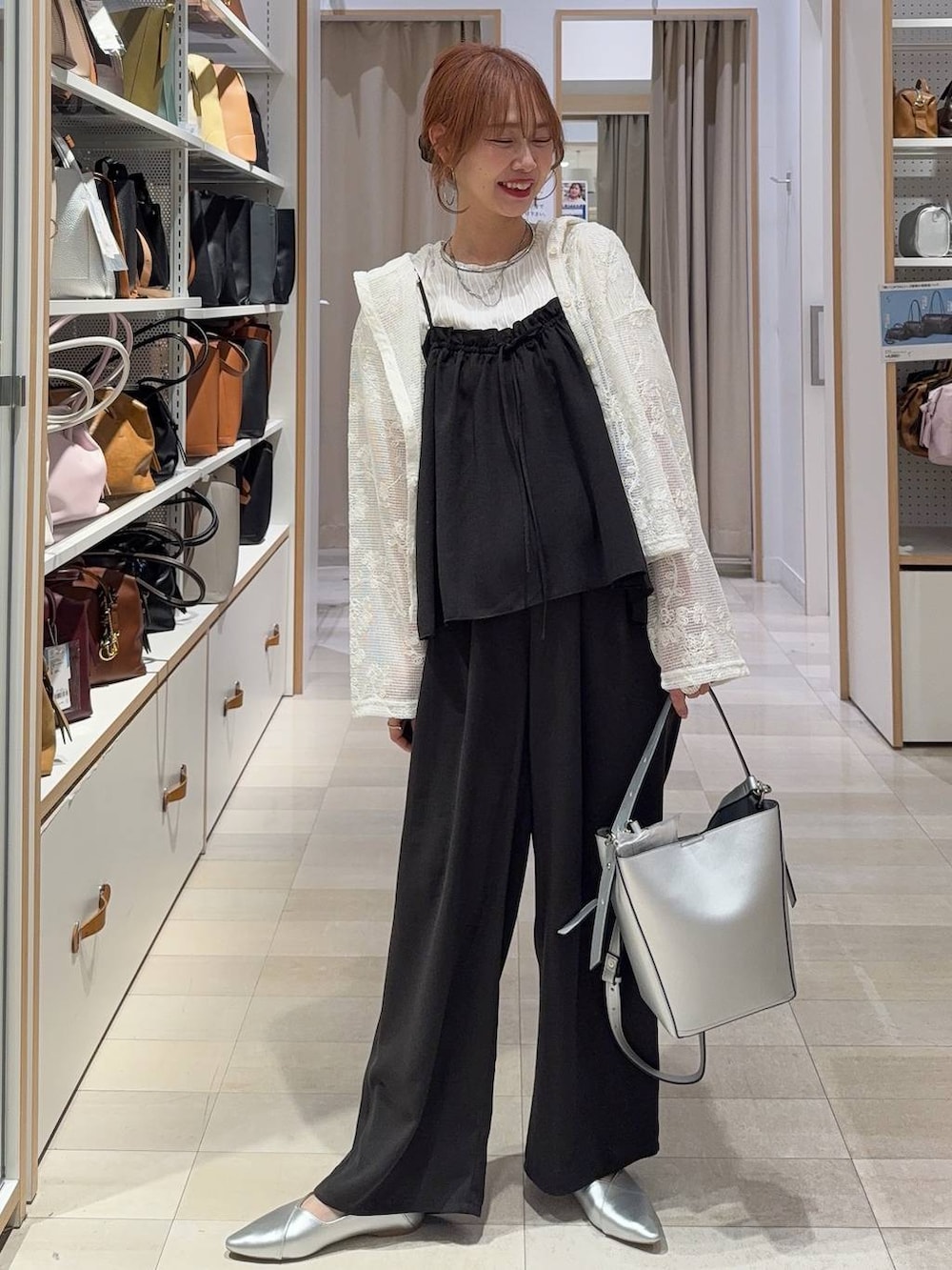 ベージュ系のパーカー、ホワイト系のタンクトップ、ブラック系のトートバッグを着用したレディースの春コーディネートの2枚目の写真