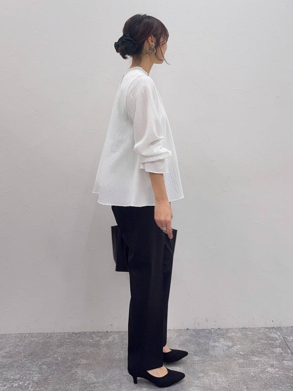 ブラック系のパンプス、ホワイト系のシャツ/ブラウス、ブラック系のスラックスを着用したレディースの冬コーディネートの8枚目の写真