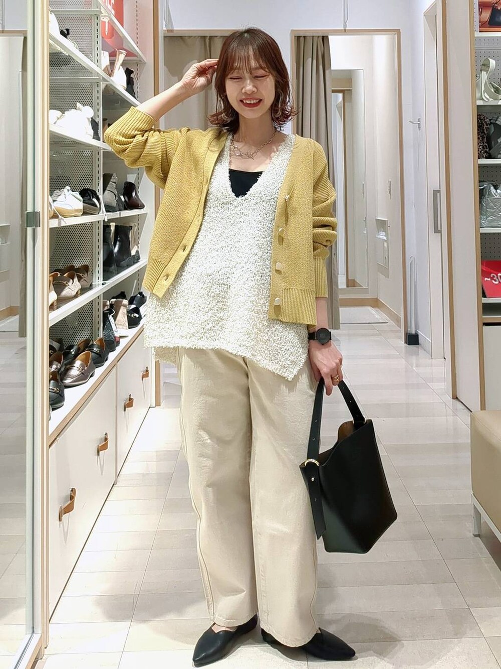 ベージュ系のデニムパンツ、ブラック系のショルダーバッグ、イエロー系のカーディガン/ボレロを着用したレディースの春コーディネートの4枚目の写真