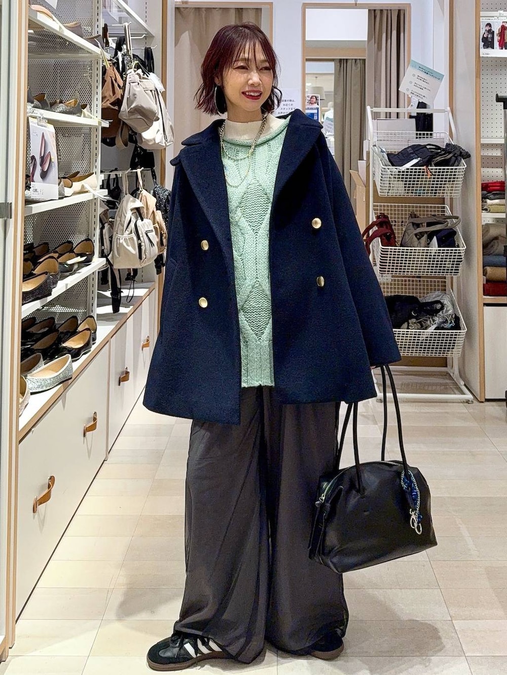 ブルー系のデニムパンツ、イエロー系のショルダーバッグ、ホワイト系のステンカラーコートを着用したレディースの冬コーディネートの4枚目の写真