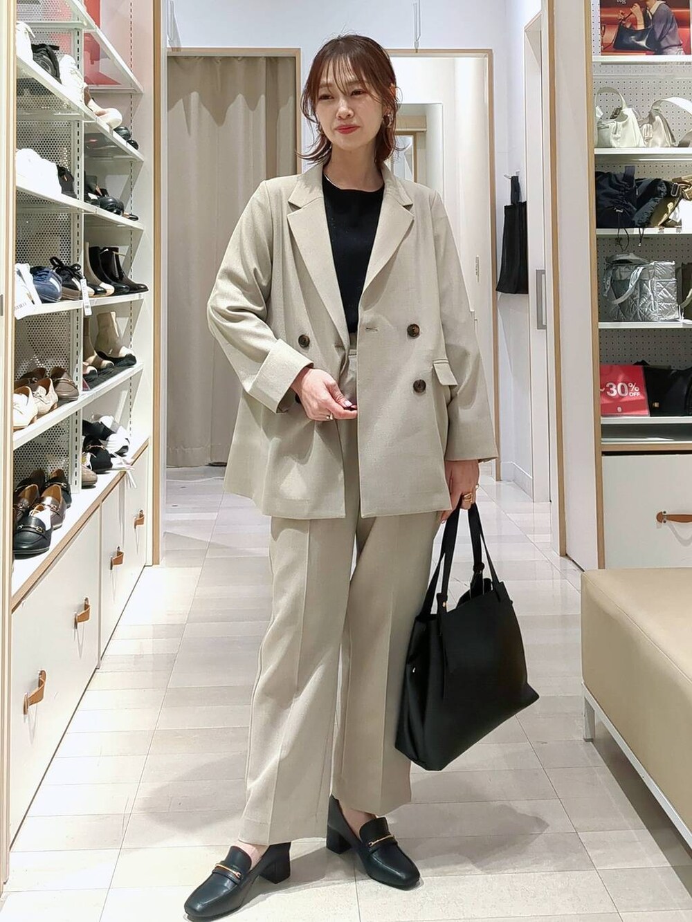 ブラック系のローファー、ブラック系のニット/セーター、ベージュ系のその他パンツを着用したレディースの春コーディネートの2枚目の写真