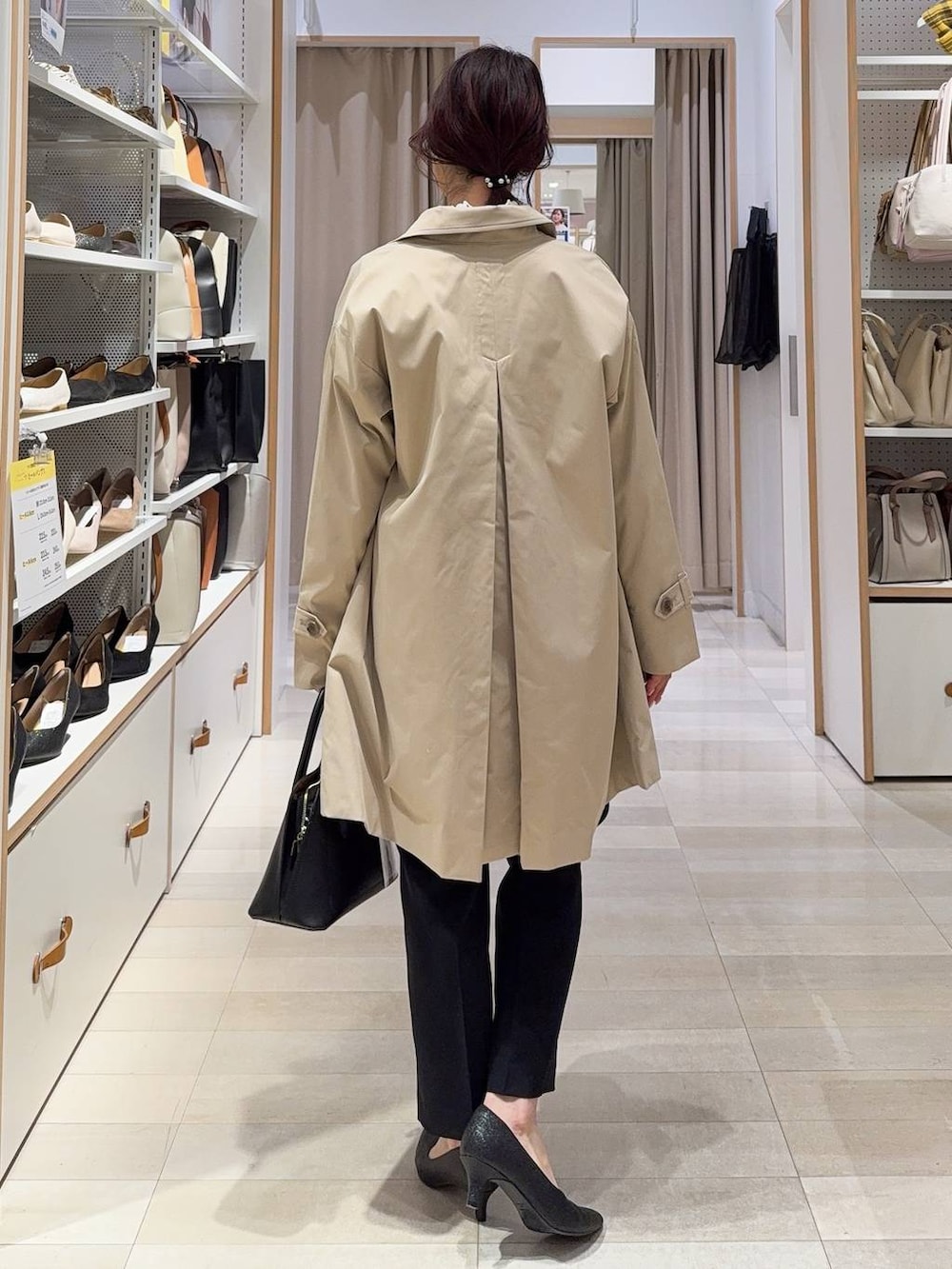 ホワイト系のショルダーバッグ、ブラック系のパンプス、ブラック系のセットアップを着用したレディースの冬コーディネートの5枚目の写真