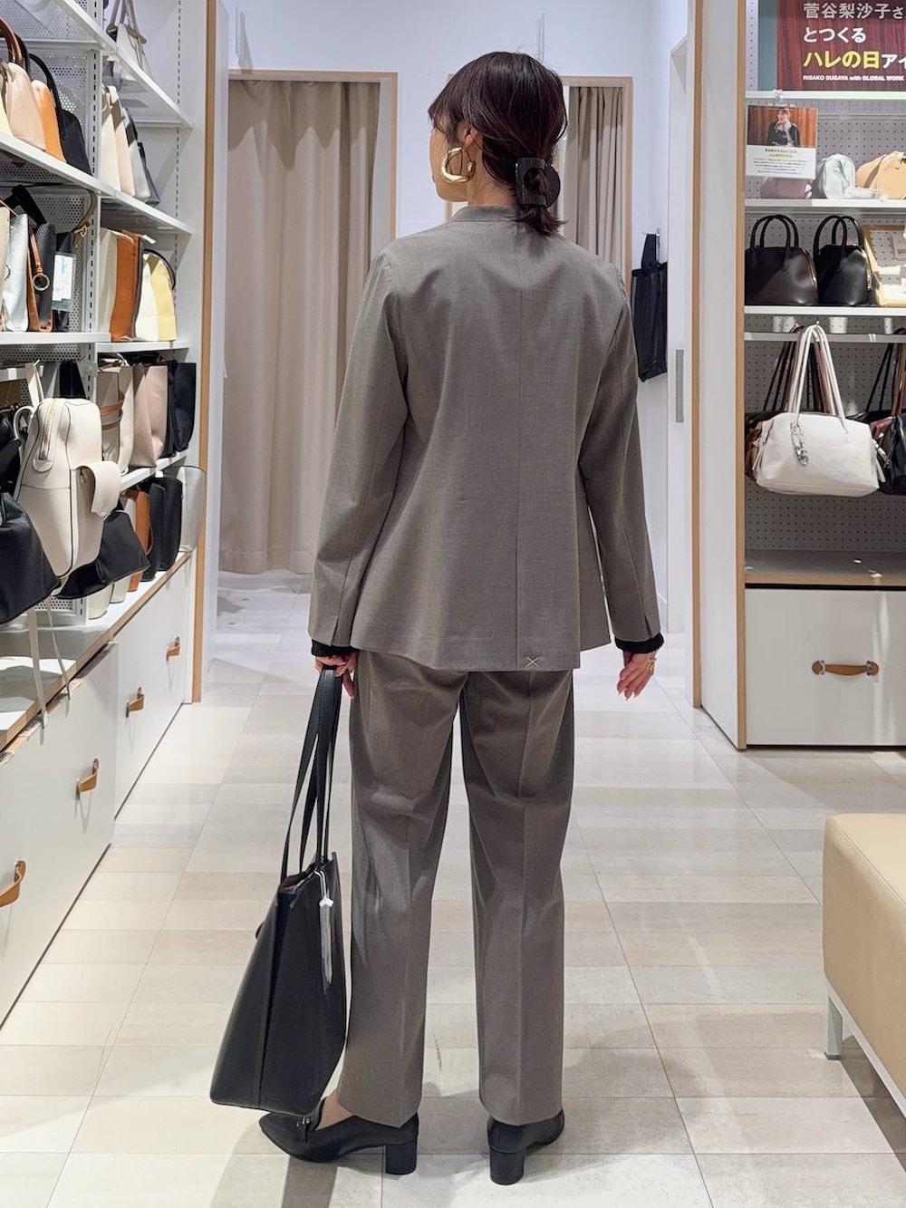 ブラウン系のスラックス、ブラック系のTシャツ/カットソー、ブラック系のトートバッグを着用したレディースの冬コーディネートの7枚目の写真