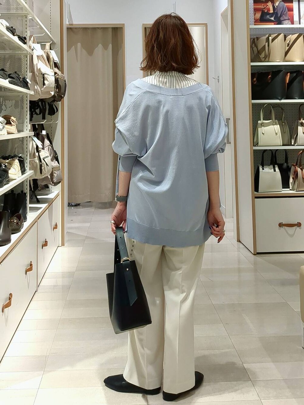 ホワイト系のその他パンツ、ブラック系のその他シューズ、ブラック系のショルダーバッグを着用したレディースの春コーディネートの4枚目の写真