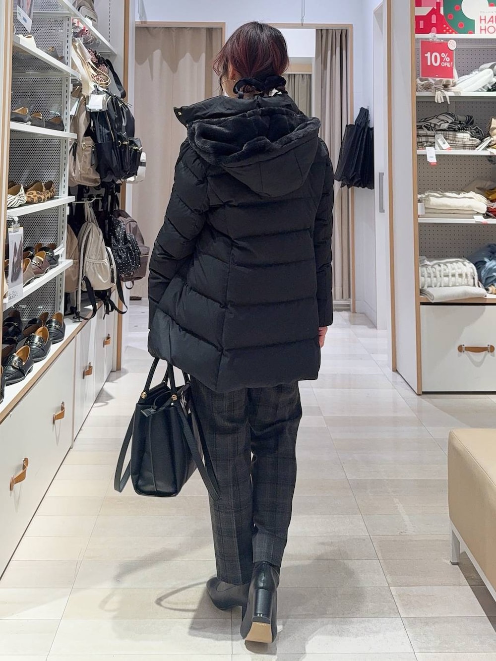 ブラック系のダウンジャケット/コート、ブラック系のその他パンツ、グレー系のニット/セーターを着用したレディースの冬コーディネートの5枚目の写真