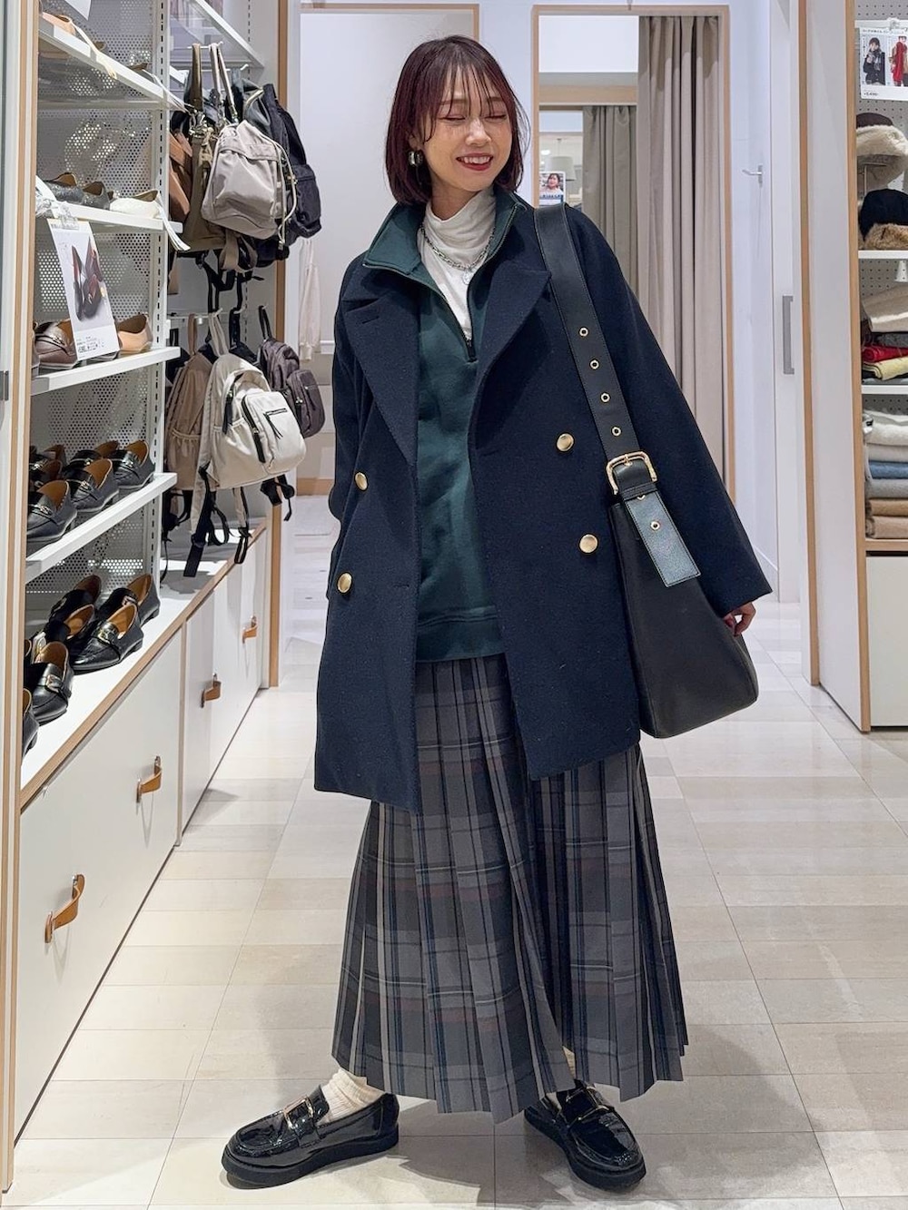 ブラック系のローファー、ブルー系のチェスターコート、グレー系のその他パンツを着用したレディースの冬コーディネートの4枚目の写真