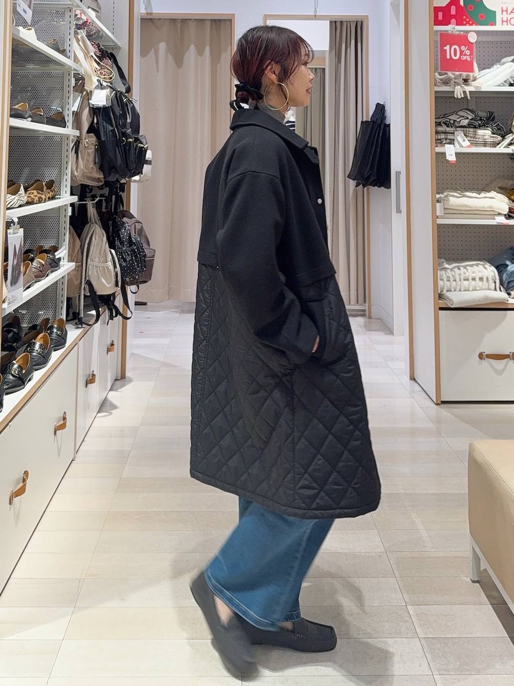 グリーン系のショルダーバッグ、ブラック系のステンカラーコート、ホワイト系のTシャツ/カットソーを着用したレディースの冬コーディネートの4枚目の写真