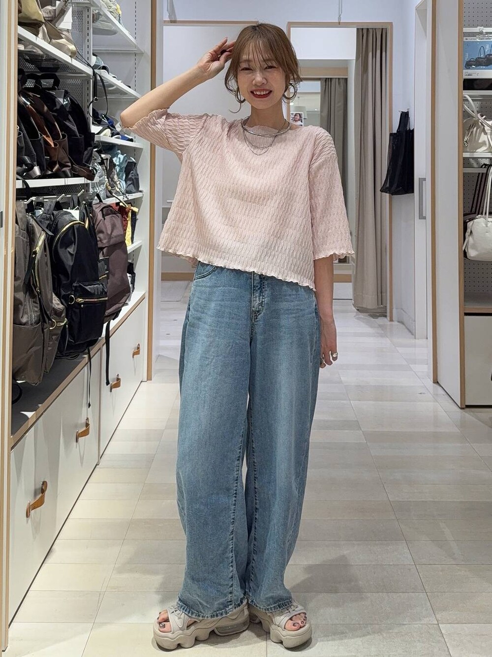 ホワイト系のキャミソール、ブルー系のデニムパンツ、ブラック系のニット/セーターを着用したレディースの春コーディネートの5枚目の写真