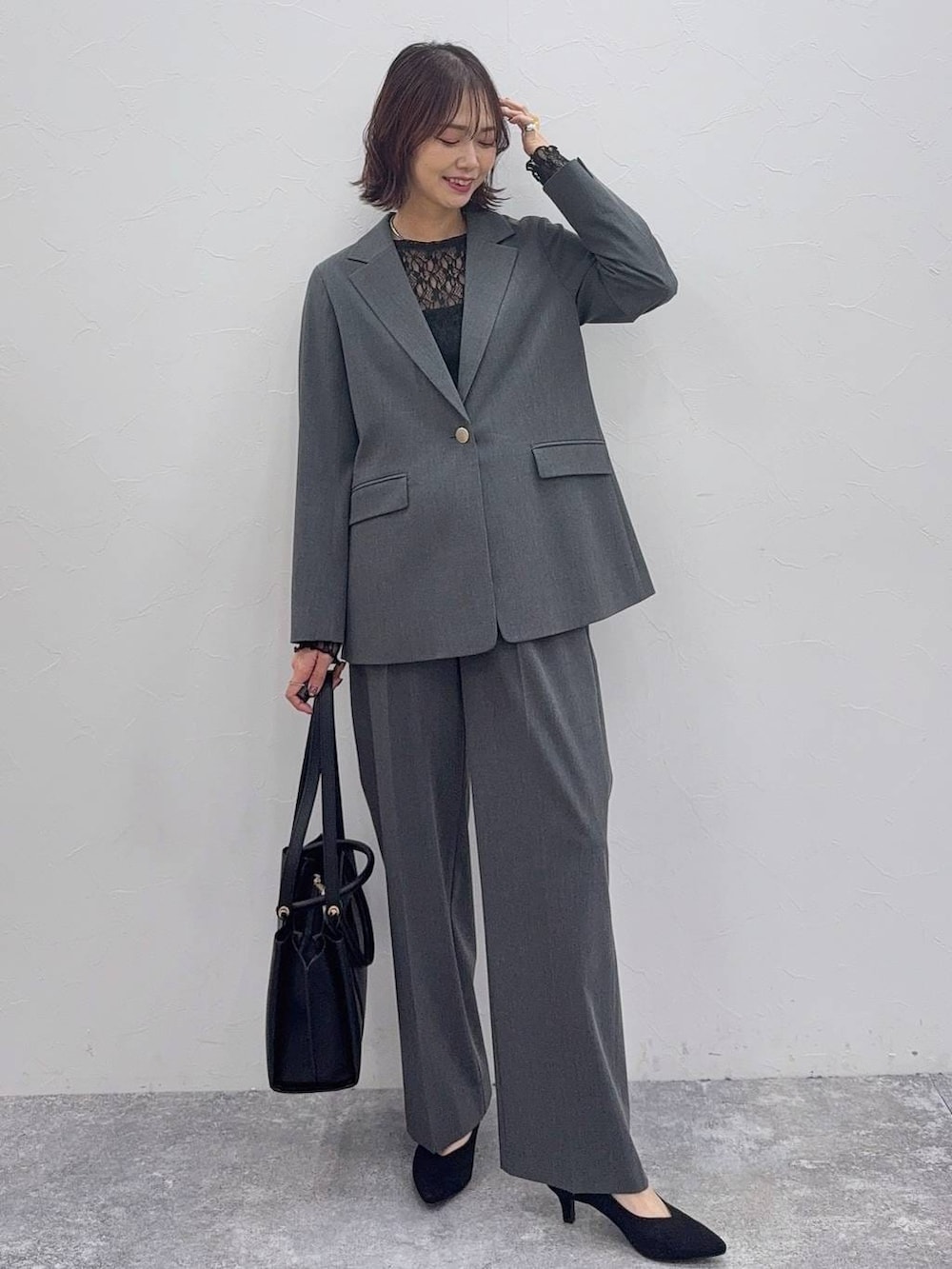 ブラック系のローファー、グレー系のスラックス、ブラック系のトートバッグを着用したレディースの冬コーディネートの5枚目の写真